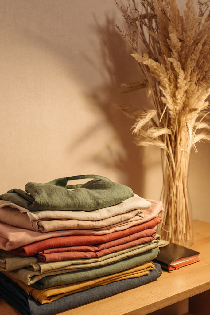 A stack of fall colored clothes, showing how to reboot your style for ageless self-expression.