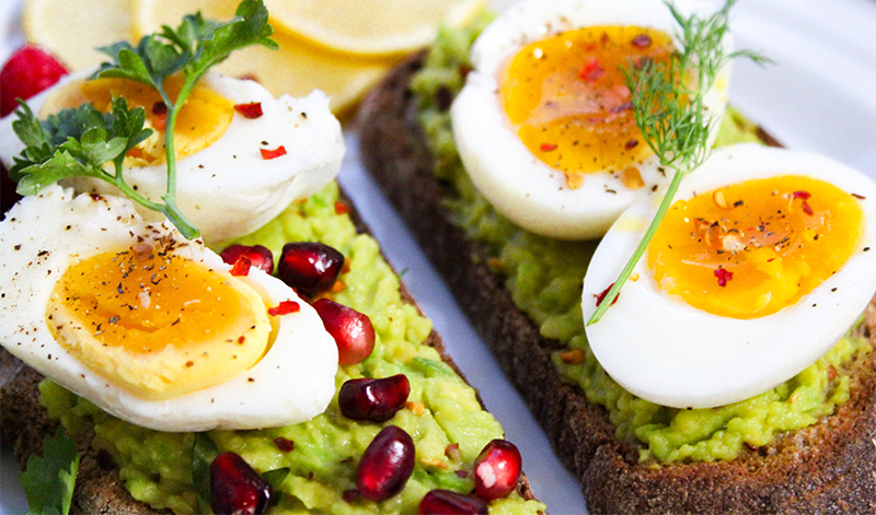 A healthy breakfast of soft-boiled eggs on avocado toast as part of a good morning routine.