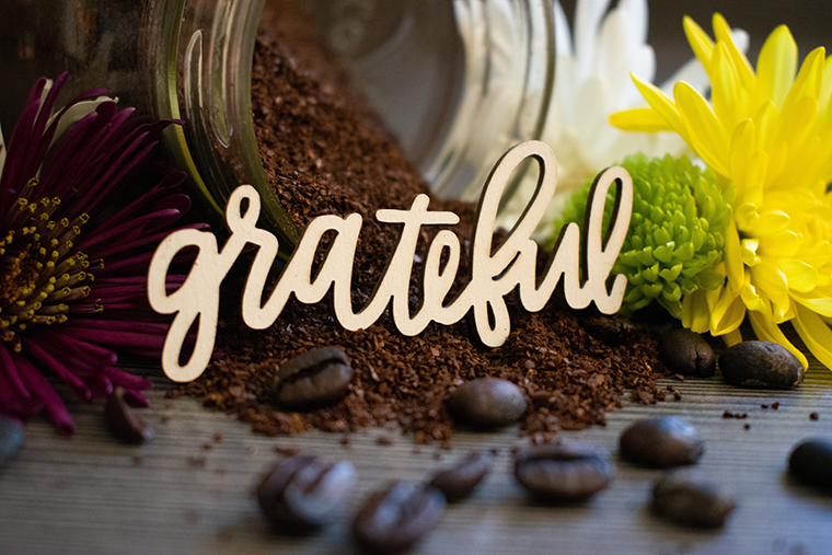 The word 'grateful', among coffee beans and flowers